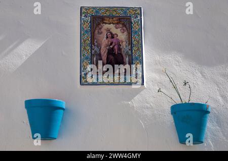 Bild der Jungfrau Maria, ausgestellt an einer weiß getünchten Wand in Frigiliana, einem der renommierten weißen Dörfer Andalusiens, Südspanien Stockfoto