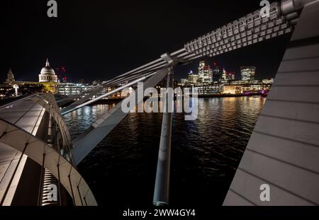 London, Großbritannien: Die Stadt London mit St Paul's Cathedral und der Themse bei Nacht von der Millennium Bridge aus gesehen. Stockfoto