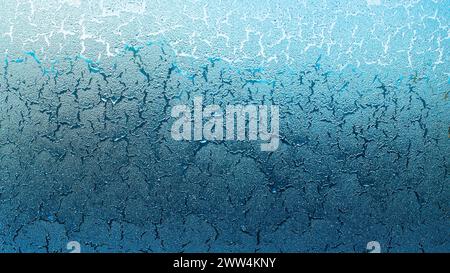 Blauer Farbton ähnelt einer zerrissenen Erde, die sich auf einem frostigen Autofenster gebildet hat Stockfoto