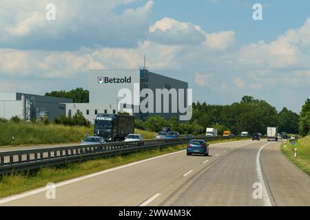 Fahrzeuge, die auf einer Autobahn unter klarem Himmel fahren, mit einem großen Betzold-Schild auf einem angrenzenden Gebäude. Stockfoto