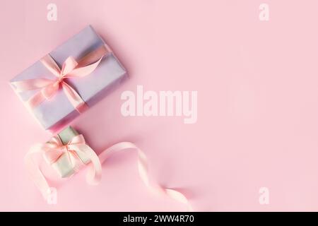 Grußkarte mit zwei Geschenkboxen mit rosa Schleifenschleifen. Draufsicht mit Platz für Ihre Grüße auf rosafarbenem Hintergrund. Frühlingsferien, Geschenk. Valentinstag Stockfoto