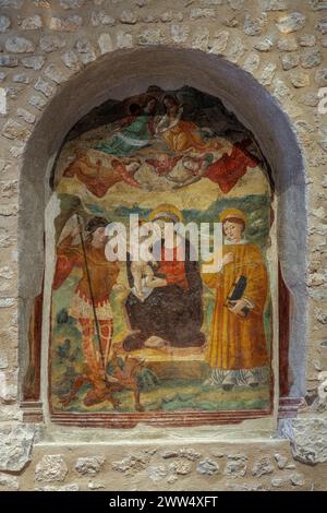 In einer Nische der Basilika Santa Maria di Collemaggio, ein Fresko, das eine Madonna mit Kind und Heiligen darstellt. L'Aquila, Abruzzen, Italien, Europa Stockfoto
