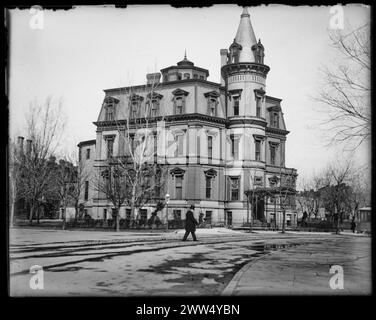 Stewart's Castle - Dupont Circle; besetzt von der chinesischen Gesandtschaft; Washington, DC; Ein Mann überquert die Straße vor einem großen hellen Steingebäude mit dunklen Zierleisten und einem hohen runden Turm mit einer spitzen Spitze. Schwarz-weiß, ca. 1890er Jahre Foto: Ervin S. Hubbard Stockfoto