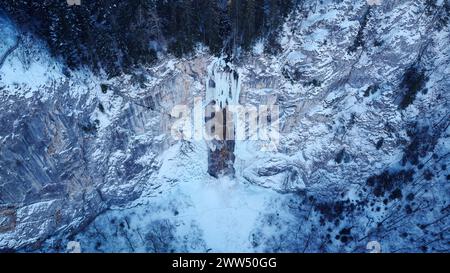 Drohnenansicht eines teilweise gefrorenen Wasserfalls aus der Luft. Wunderschöne und zauberhafte Winterurlaubslandschaft für Naturliebhaber. Skakavac Wasserfall in Sarajevo. Stockfoto