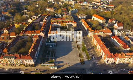 Eine Drohnenaufnahme fängt das Stadtzentrum von Koszalin im goldenen Licht ein, mit der Kathedrale, der Victory Street und dem Rathaus. Stockfoto