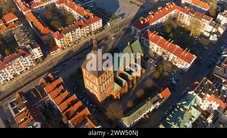 Eine Drohnenaufnahme fängt das Stadtzentrum von Koszalin im goldenen Licht ein, mit der Kathedrale, der Victory Street und dem Rathaus. Stockfoto