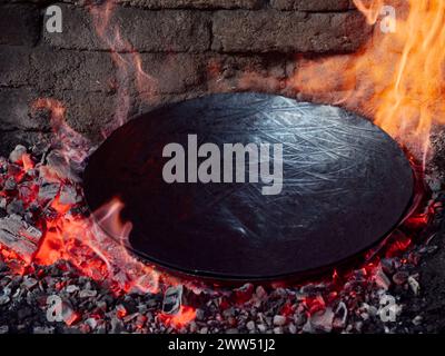 Schmiede, die an der Herstellung von Töpfen für traditionelle Mahlzeiten unter der Glocke (Peka oder Sač) arbeiten. Altes traditionelles Kunsthandwerk. Stockfoto