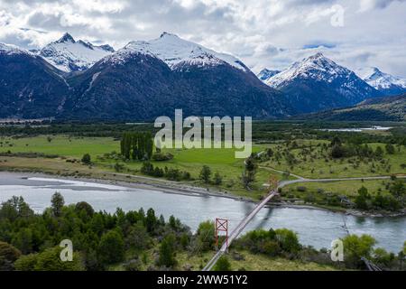 Alte Hängebrücke über den Fluss Rio Nadis südlich von Cochrane, schneebedeckte Berge am Rio Baker im Hinterland, Patagonien, Chile Stockfoto