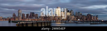 Panoramablick auf die Skyline von Manhattan über den Hudson River vom Walkway am Wasser in Jersey City in hellem Abendlicht Stockfoto