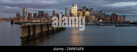 Panoramablick auf die Skyline von Manhattan über den Hudson River vom Waterfront Walkway in Jersey City in der Abenddämmerung Stockfoto