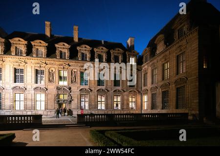 Hotel de Sully, ein privates Herrenhaus im Marais, Paris, beleuchtet in der Abenddämmerung. Stockfoto