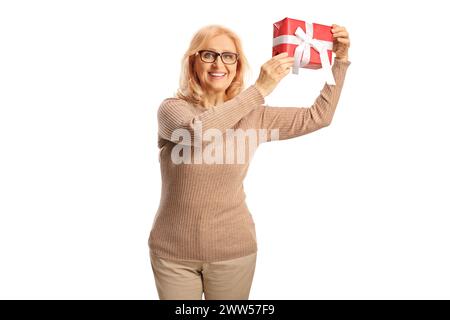 Glückliche Frau mittleren Alters, die ein Geschenk isoliert auf weißem Hintergrund hält Stockfoto