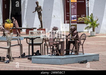 Cartagena, Kolumbien - 25. Juli 2023: Plaza de San Pedro Claver, Platz. Rost-Metall-Kunstwerke präsentieren, ein Schachspieler. Die Fassade des Kunstmuseums hinten Stockfoto