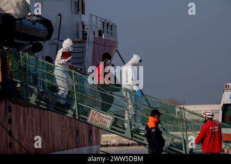 Ravenna, Italien. März 2024. Gesundheitskontrollärzte begleiten einen Migranten, der aus dem Schiff aussteigt, das im Hafen von Ravenna angekommen ist das Rettungsschiff Life Support landete um 8:00 Uhr morgens im Hafen von Ravenna mit 71 Migranten an Bord, die während ihrer Schifffahrt auf See gerettet wurden. Quelle: SOPA Images Limited/Alamy Live News Stockfoto