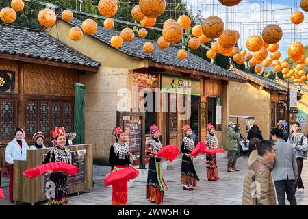 Kunming, China. Dezember 2023. Künstler demonstrieren verschiedene Kulturen im Yunnan Ethnic Village in Kunming, Yunnan, China am 6. Dezember 2023. Das Ethik-Dorf am Nordufer des Dianchi-Sees ist ein Freizeitpark von 25 ethnischen Minderheiten, die in der Provinz Yunan leben. (Foto: Samuel Rigelhaupt/SIPA USA) Credit: SIPA USA/Alamy Live News Stockfoto