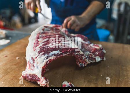 Der Metzger versucht, ein Kalb in einer Metzgerei zu ziehen oder zu schneiden. Hochwertige Fotos Stockfoto