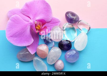 Amethyst-Kristalle, Rosenquarz und Orchideenblüte. Heilkristalle, die Magie der Edelsteine. Stockfoto