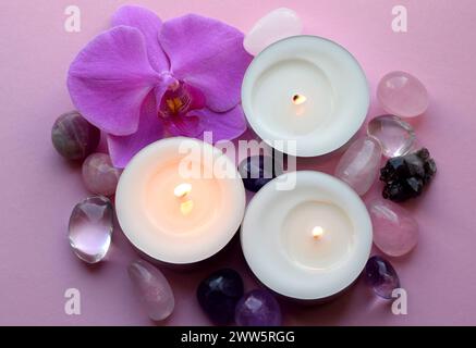 Wunderschöne Kristalle, Orchideenblüten und Kerzen. Heilkristalle, die Magie der Edelsteine. Stockfoto