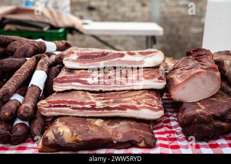 Bild von serbischem Speck und anderen geräucherten Fleischprodukten sowie gepökeltem Fleisch zum Verkauf auf einem serbischen Markt in Kacarevo. Stockfoto