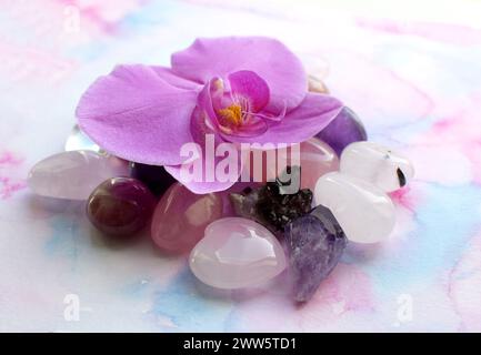 Wunderschöne Amethyst-Kristalle und Orchideenblume. Heilkristalle, die Magie der Edelsteine. Stockfoto