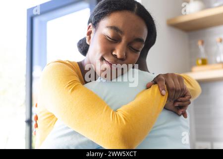 Afroamerikaner teilen sich eine warme Umarmung zu Hause in der Küche Stockfoto