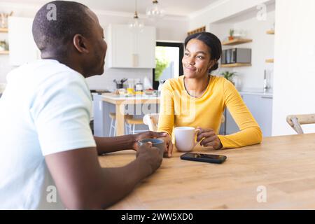 Afroamerikaner-Paar unterhält sich bei einem Kaffee zu Hause in der Küche Stockfoto