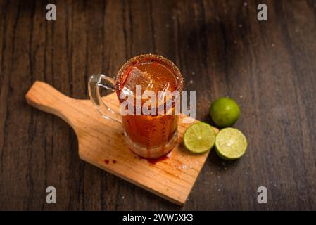 Michelada, typisch mexikanischer Cocktail auf einem Holztisch. Bier-Cocktail. Stockfoto