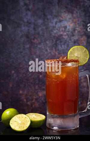 Michelada, typisch mexikanischer Cocktail auf einem Holztisch. Bier-Cocktail. Stockfoto