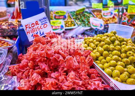 MALAGA, SPANIEN - 28. SEPTEMBER 2019: Der Stand des Atarazanas Central Market mit kandiertem Hibiskus und Salzoliven, am 28. September in Malaga Stockfoto