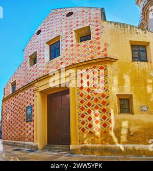 Die mit Fresken geschmückte Fassadenwand der mittelalterlichen Kirche San Juan Bautista in Malaga, Spanien Stockfoto