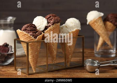 Leckere Eislöffel in Waffelkegeln auf Holztisch, Nahaufnahme Stockfoto
