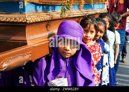 Antigua, Guatemala. März 2024. Junge guatemaltekische Kinder, von denen einige in den Gewändern eines Bußgeländes gekleidet sind, lernen vor Beginn der Heiligsten Woche, 21. März 2024 in Jocotenango, Guatemala, wie man einen religiösen Palanquin trägt. Die opulenten Prozessionen, detailgetreuen Alfombras und jahrhundertealten Traditionen ziehen mehr als 1 Million Menschen in die alte Hauptstadt. Quelle: Richard Ellis/Richard Ellis/Alamy Live News Stockfoto