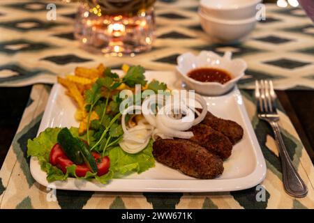 lula Pommes Frites Salat Seitenansicht auf einem Tisch in einem Restaurant aus nächster Nähe Stockfoto