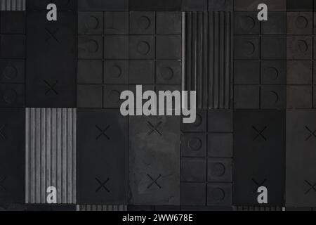 Strukturierter grauer, schwarzer geometrischer Hintergrund aus Beton, Paste mit Streifen, Quadraten, Kreisen, Kreuzen, tic-Tac-Toe, Kopierraum. Konzept abstrakter moderner Wandgestaltung mit voluminösen konvexen Elementen Stockfoto