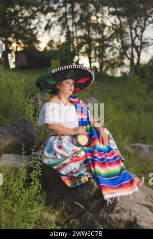 Frau mit mexikanischem Hut in ländlicher Landschaft. Cinco de Mayo-Feier in Mexiko. Stockfoto