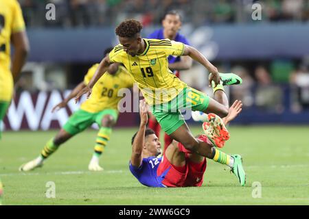 Arlington, Texas, USA. März 2024. Jamaikas JAMAL LOWE (19) stolpert während des Spiels der CONCACAF Nations League am Donnerstag im AT&T Stadium in Arlington, Texas, über MILES ROBINSON (12) der USA. (Kreditbild: © Brian McLean/ZUMA Press Wire) NUR REDAKTIONELLE VERWENDUNG! Nicht für kommerzielle ZWECKE! Stockfoto