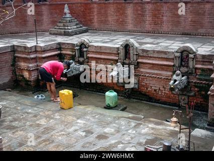 Kathmandu, Bagmati, Nepal. März 2024. Ein nepalesischer Mann füllt Wasser aus einem traditionellen Steinhahn in Kathmandu, Nepal, am 22. März 2024, dem Weltwassertag. Die Bevölkerung des Kathmandu-Tals ist nach wie vor mit dem Problem der Trinkwasserknappheit aufgrund der wachsenden Bevölkerung und der Urbanisierung konfrontiert. (Kreditbild: © Sunil Sharma/ZUMA Press Wire) NUR REDAKTIONELLE VERWENDUNG! Nicht für kommerzielle ZWECKE! Stockfoto