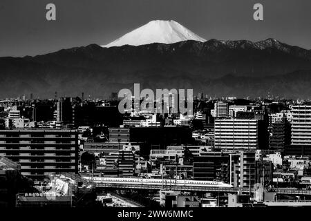 Tokio, Japan. März 2024. Die Skyline des südlichen Tokios mit dem Mt. Fuji (Fujian) am Morgen mit einem JR Central Nozomi Shinkansen, der durch die Stadtlandschaft fährt. Der Nikkei 225 stellte einen neuen Rekord auf, als die japanische Wirtschaft auf die Ankündigung der Negativzinsen reagiert, um die Inflation zu zähmen. (Kreditbild: © Taidgh Barron/ZUMA Press Wire) NUR REDAKTIONELLE VERWENDUNG! Nicht für kommerzielle ZWECKE! Stockfoto