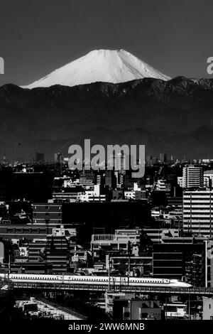 Tokio, Japan. März 2024. Die Skyline des südlichen Tokios mit dem Mt. Fuji (Fujian) am Morgen mit einem JR Central Nozomi Shinkansen, der durch die Stadtlandschaft fährt. Der Nikkei 225 stellte einen neuen Rekord auf, als die japanische Wirtschaft auf die Ankündigung der Negativzinsen reagiert, um die Inflation zu zähmen. (Kreditbild: © Taidgh Barron/ZUMA Press Wire) NUR REDAKTIONELLE VERWENDUNG! Nicht für kommerzielle ZWECKE! Stockfoto