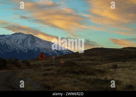 Ländliche Straße mit Geschwindigkeitsschildern und Männern, die arbeiten. Patagonien, Chile Stockfoto