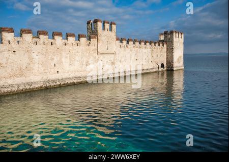 Wächter der Geschichte: Ein herrlicher Blick auf die antiken Steinmauern und die Türme der Burg Sirmione, die sich am Ufer des Gardasees thront Stockfoto