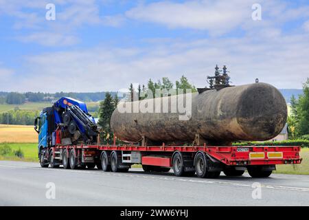 Der Volvo FH Truck transportiert an einem Sommertag den alten Tankcontainer auf einem Anhänger entlang der Straße, Rückansicht. Lange Transporte. Pirkanmaa, Finnland. August 2022. Stockfoto