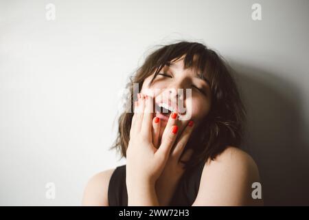 Porträt einer lebenslustigen halb-asiatischen Frau, die mit Kopierraum lacht Stockfoto