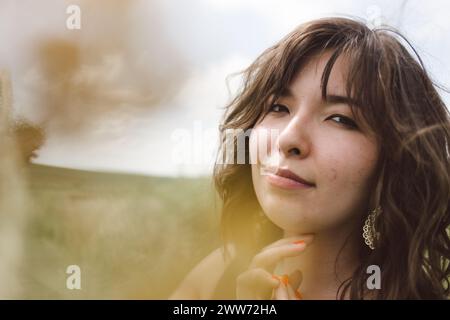 Nahporträt einer halbasiatischen Frau im ländlichen Raum durch verschwommenen Vordergrund Stockfoto