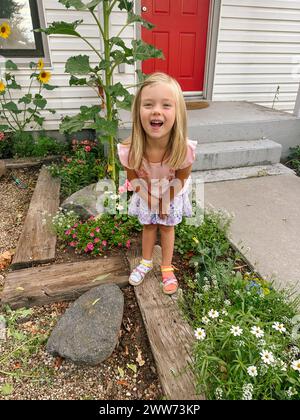 Fröhliches Kind lächelt in einem bunten Sommergarten Stockfoto