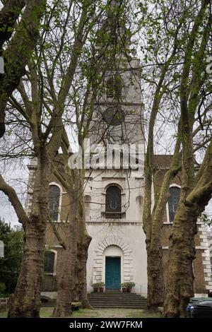 St. James's Church, Clerkenwell, London. Die ruhige Fassade der Kirche wird von den majestätischen Bäumen des umliegenden Gartens eingerahmt Stockfoto