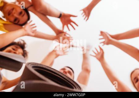 Multirassisch lächelnde Menschen mit Matten nach Yoga in einem Fitnessclub. Eine Gruppe junger sportlicher Frauen und Männer nach körperlichen Übungen im Fitnessstudio. In Stockfoto