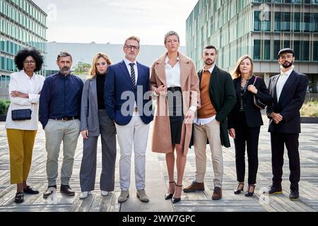 Multirassische Geschäftsleute, die außerhalb des Finanzviertels stehen und selbstbewusst in die Kamera schauen. Stockfoto