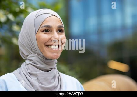 Elegante und moderne junge Frau mit Hijab vor urbanem Hintergrund, die Selbstbewusstsein und Stil ausstrahlt. Stockfoto