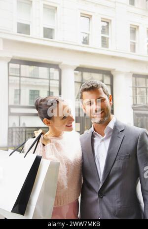 Lächelnde paar auf Stadtstraße mit Einkaufstüten Stockfoto